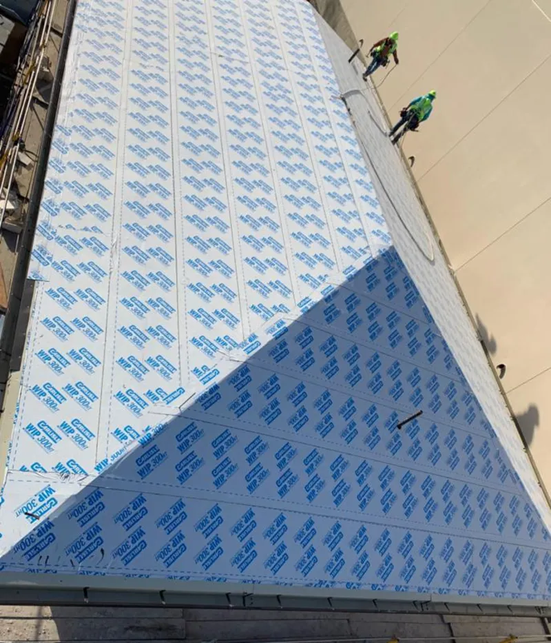 Professional roofers installing underlayment on a metal roof in East Manchester